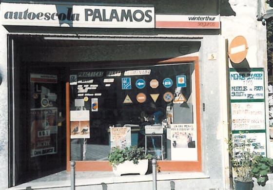 Façana del local original d'Autoescola Palamós amb senyals de trànsit exposades